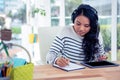 Smiling Asian woman with headphones writing on notepad Royalty Free Stock Photo