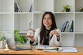 Asian woman holding house model and house key in hand. Real estate investment and insurance concept. Royalty Free Stock Photo