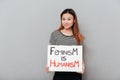 Smiling asian woman holding poster with slogan