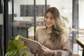 Smiling woman owner standing at her coffee shop and using digital tablet. Royalty Free Stock Photo