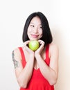 Smiling asian woman red dress with green apple on white Royalty Free Stock Photo