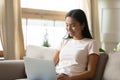 Smiling Asian woman relax at home using modern laptop Royalty Free Stock Photo