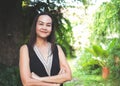 Smiling Asian woman standing in  garden with arms crossed looking to camera. heath and happiness, spending time alone at home Royalty Free Stock Photo