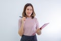 Smiling asian woman taking notes with pen on clipboard, looking happy Royalty Free Stock Photo