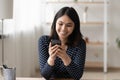 Smiling asian woman use modern cellphone at home Royalty Free Stock Photo