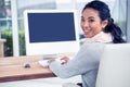 Smiling Asian woman using computer looking back at the camera Royalty Free Stock Photo