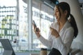 Smiling asian woman using mobile phone and holding credit card for online payment or online shopping. Royalty Free Stock Photo