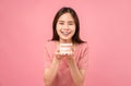 Asian woman wearing braces holding tooth model on pink background. Royalty Free Stock Photo