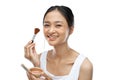 smiling asian woman wearing underdress applying make up with brush Royalty Free Stock Photo