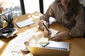 Asian woman working with laptop computer and making notes on sticky note. Royalty Free Stock Photo