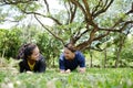 Smiling Asian young couples love exercising and planking workout together on grass field in the garden.