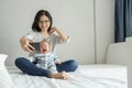 Smiling Asian Young Mother comforting or consoling her little baby son while doing online video call on smartphone. Newborn boy Royalty Free Stock Photo