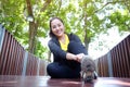 Smiling Asian young woman in black sportwear resting and tying Shoelace on wooden bridge before exercise in the garden Royalty Free Stock Photo