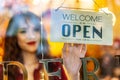 Smiling asian young woman setting open sign broad at the shop glasses for welcome the customer in to the coffee shop, Royalty Free Stock Photo