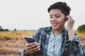 Smiling Asian young woman are short hair  listening to the podcast is a music audio mp3 player on smartphone outdoors nature Royalty Free Stock Photo