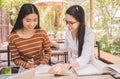 Smiling Asian young woman sitting pointing studying examining, Tutor books with friends Young students campus helps friend