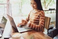 Smiling asian Young woman typing laptop keyboard and holding credit card at coffee shop with online shopping .Selective Focus Royalty Free Stock Photo