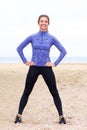 Smiling athlete standing on beach with hands on hips Royalty Free Stock Photo