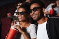 Smiling attractive afro american couple watching 3D movie Royalty Free Stock Photo