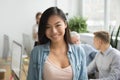 Smiling asian office employee looking at camera working with col Royalty Free Stock Photo