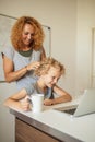 Smiling Mother helps her adorable daughter with homework at living room Royalty Free Stock Photo