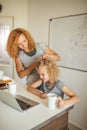 Smiling Mother helps her adorable daughter with homework at living room Royalty Free Stock Photo