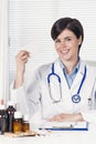 Smiling female doctor holding a business card or white pill box Royalty Free Stock Photo