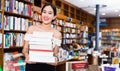 Smiling attractive girl holding pile of books bought in bookstor Royalty Free Stock Photo