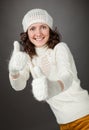 Smiling attractive girl showing thumbs up in mittens Royalty Free Stock Photo