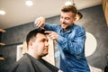 Smiling attractive hair stylist doing his job with love at barber shop