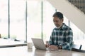 Smiling attractive mature man with white, grey stylish short beard using smartphone gadget serving internet in modern office,co-wo Royalty Free Stock Photo