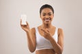 Smiling attractive millennial black woman holding deodorant in her hand Royalty Free Stock Photo