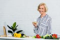 smiling attractive senior woman holding glass of white wine Royalty Free Stock Photo