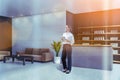 Smiling attractive woman holding tablet device and waiting for clients in reception area of modern luxury spa wellness center to