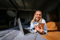 Smiling attractive woman lying on bed talking by smartphone