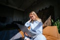 Smiling attractive woman lying on bed using laptop