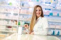 Smiling attractive woman pharmacist displaying a box of tablets or a product in her hands Royalty Free Stock Photo