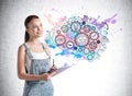 Smiling attractive young woman in denim overalls holding a planner and standing near concrete wall with creative colorful idea Royalty Free Stock Photo