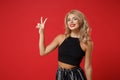 Smiling attractive young woman girl in black clothes posing isolated on bright red wall background studio portrait Royalty Free Stock Photo