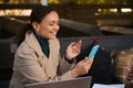 Smiling attractive young woman making a video call via a mobile app on her smartphone. Young confident business woman working Royalty Free Stock Photo