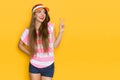 Beautiful Young Woman In Striped Shirt And Sun Visor Is Showing Hand Peace Sign