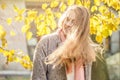 Smiling autumn woman holding yellow maple leaf. Cute Romantic girl in fall park Royalty Free Stock Photo