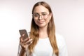 Smiling awesome female student holding smart phone