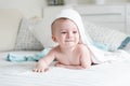 Smiling baby boy in hooded towel crawling on bed after having ba Royalty Free Stock Photo