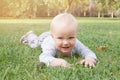 Smiling baby boy lying on the green grass outdoors Royalty Free Stock Photo