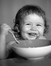 Smiling baby eating food. Funny baby eating food himself with a spoon on kitchen. Healthy nutrition for kids. Launching Royalty Free Stock Photo