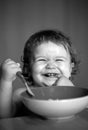 Smiling baby eating food. Launching child with spoon. Royalty Free Stock Photo