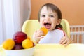 Smiling baby eating fruits Royalty Free Stock Photo