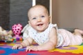 Smiling baby girl with blue eyes playing on floor Royalty Free Stock Photo
