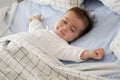 Smiling baby girl lying on a bed sleeping Royalty Free Stock Photo